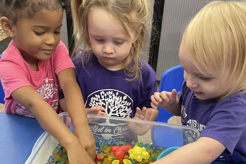 Three K3 students playing with water beads