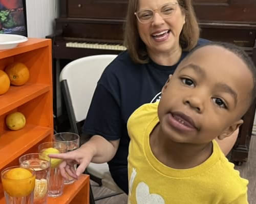 A teacher and student learning together about boyancy in an orange floating experiment.