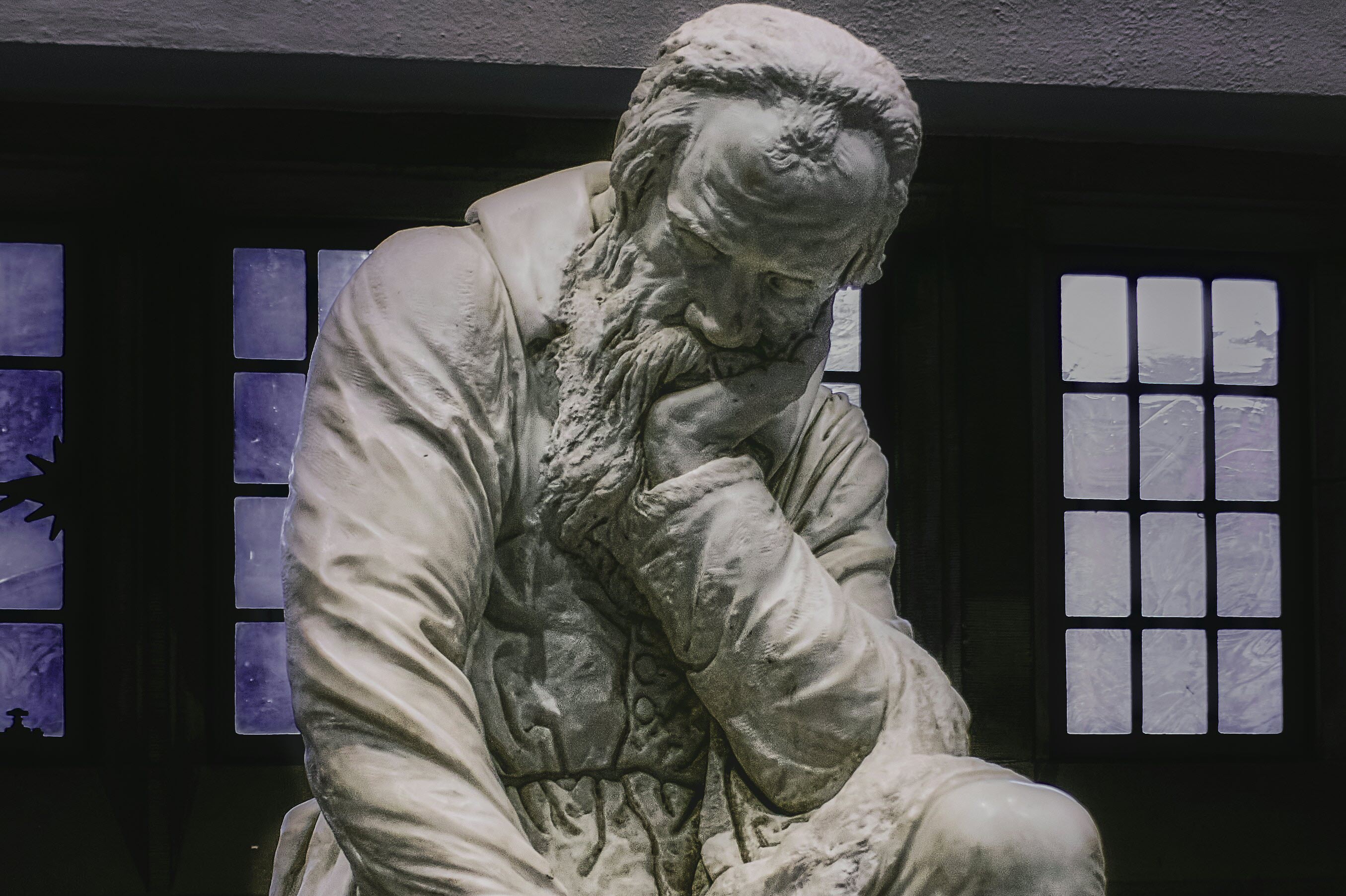 A statue of a Philosopher sitting and thinking.